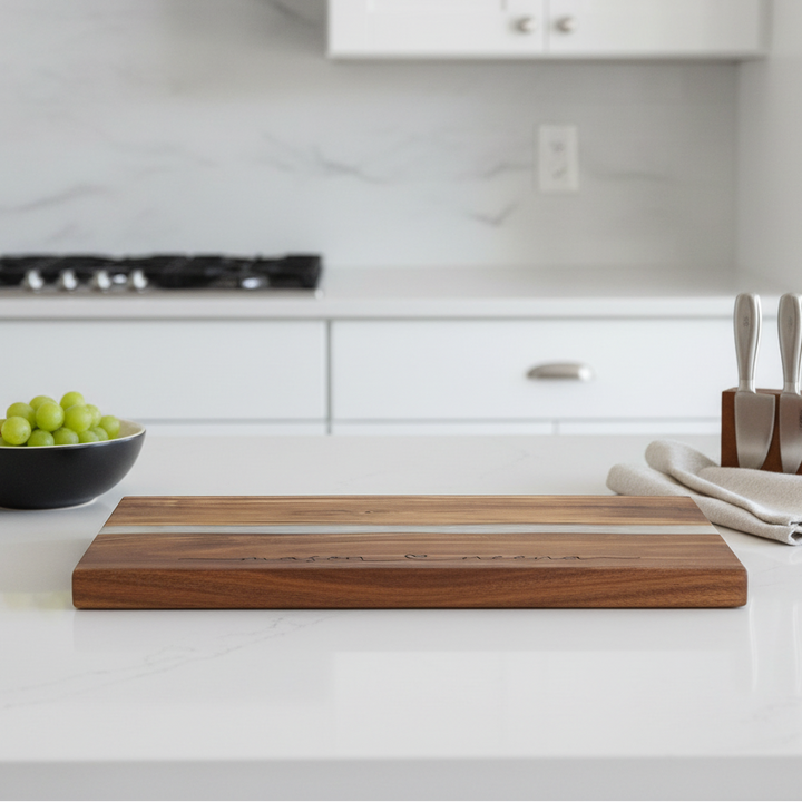 Wooden cutting board on a kitchen counter with a bowl of grapes and a knife block.