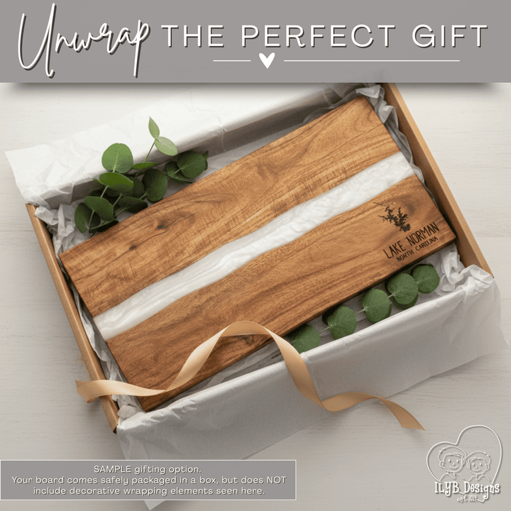Wooden cutting board with engraved text in a gift box on a light background