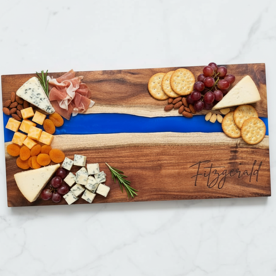 Wooden charcuterie board with engraved last name with assorted cheeses, fruits, and crackers on a white surface.