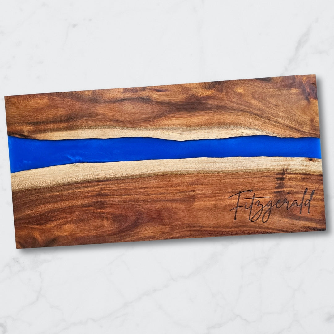 Wooden cutting board with blue resin inlay and 'Fitzgerald' branding on a white background