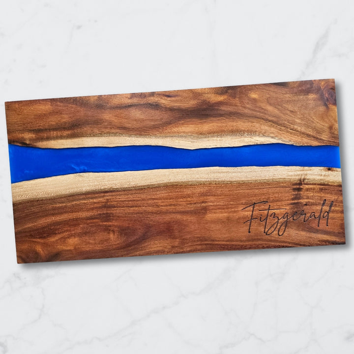 Wooden cutting board with blue resin inlay and 'Fitzgerald' branding on a white background