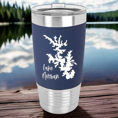 20 ounce stainless steel tumbler with navy blue silicone sleeve that's laser engraved in white. There's a silhouette of a lake and the name Lake Norman next to it in a fun modern script font.