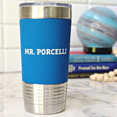 Blue stainless steel tumbler with a personalized teacher name laser engraved in white.