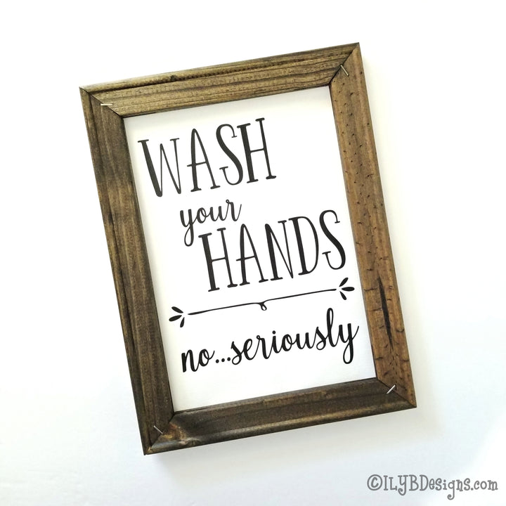 Dark walnut stained 9"x12" frame on a white canvas with black words that read, "Wash your hands, no...seriously." Design is placed vertically on sign.