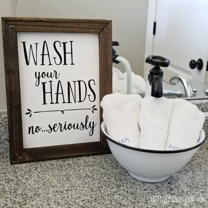 Dark walnut stained 9"x12" frame on a white canvas with black words that read, "Wash your hands, no...seriously." Design is placed vertically on sign.