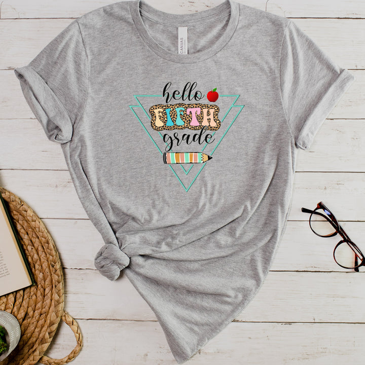 Athletic heather gray grade level team teacher shirt featuring colorful retro letters with leopard print behind them and says hello fifth grade along with a pencil and apple.