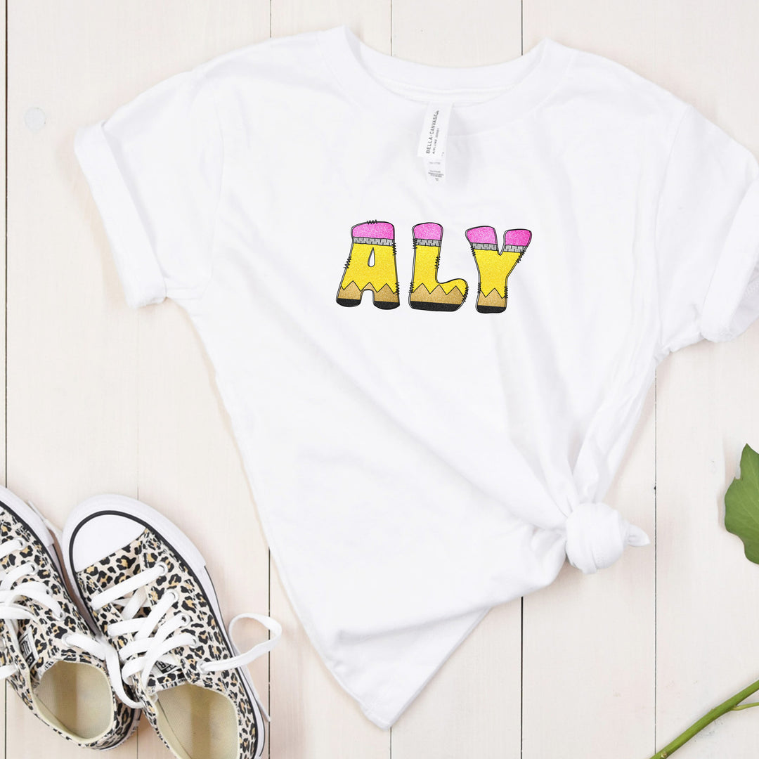 Youth white personalized name shirt for back to school with doodle letters that resemble school pencils to spell out your childs name.