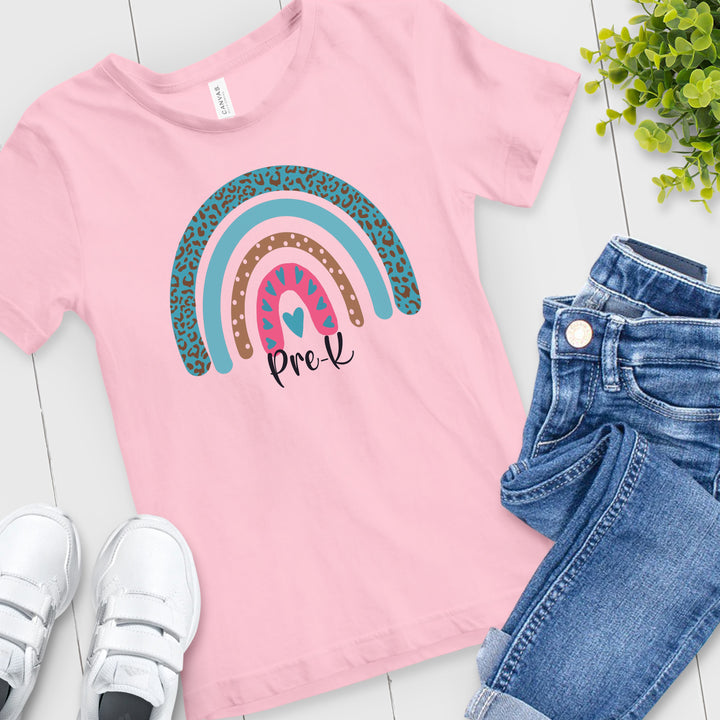 Pink toddler shirt with pink and teal leopard print rainbow. Under rainbow in black script is custom grade level.