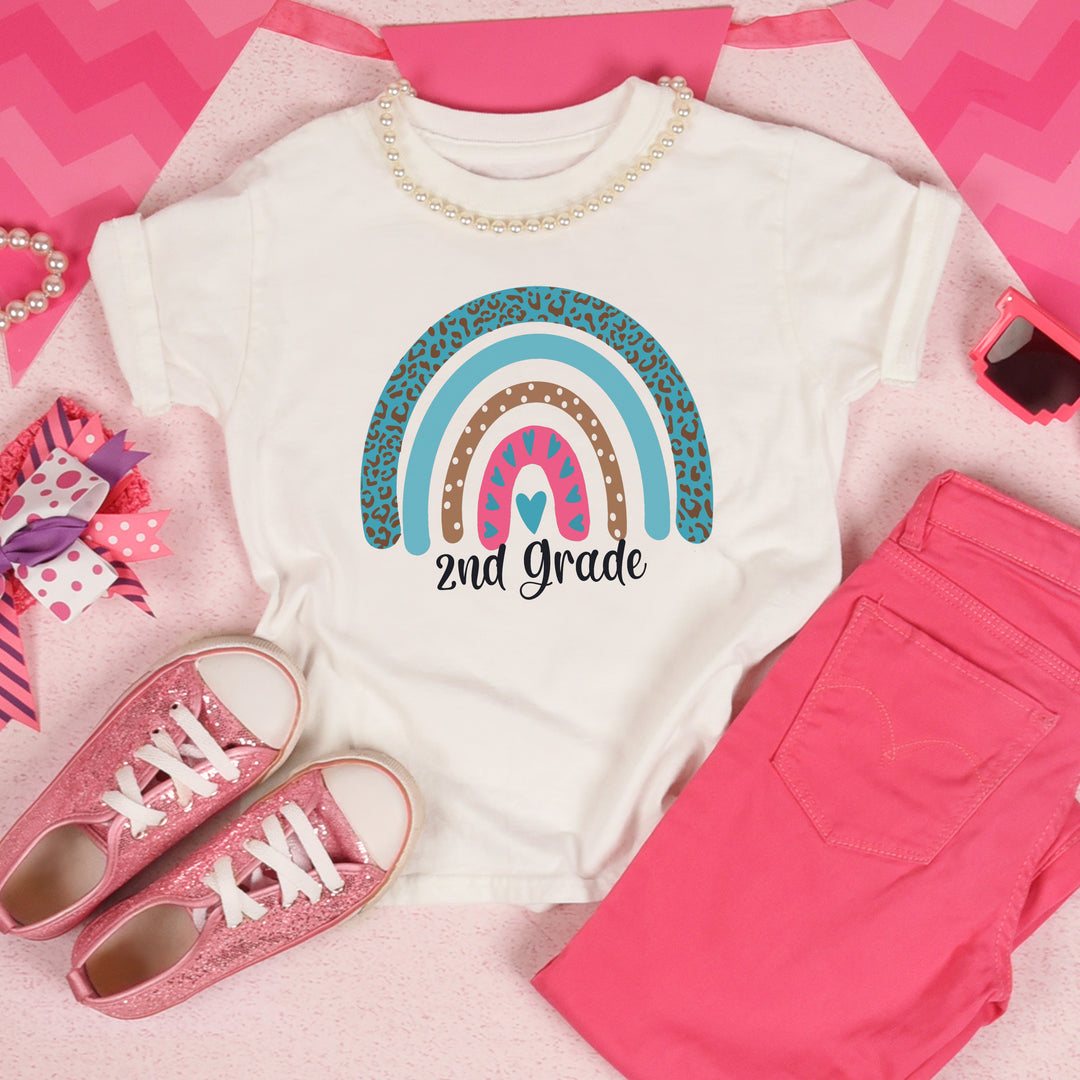 White toddler shirt with pink and teal leopard print rainbow. Under rainbow in black script is custom grade level.