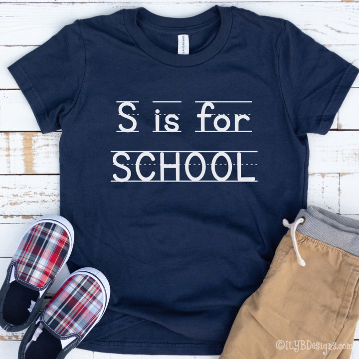 Navy S is for School back to school shirt with a playful print font, complete with elementary lined writing lines. Design is in black.