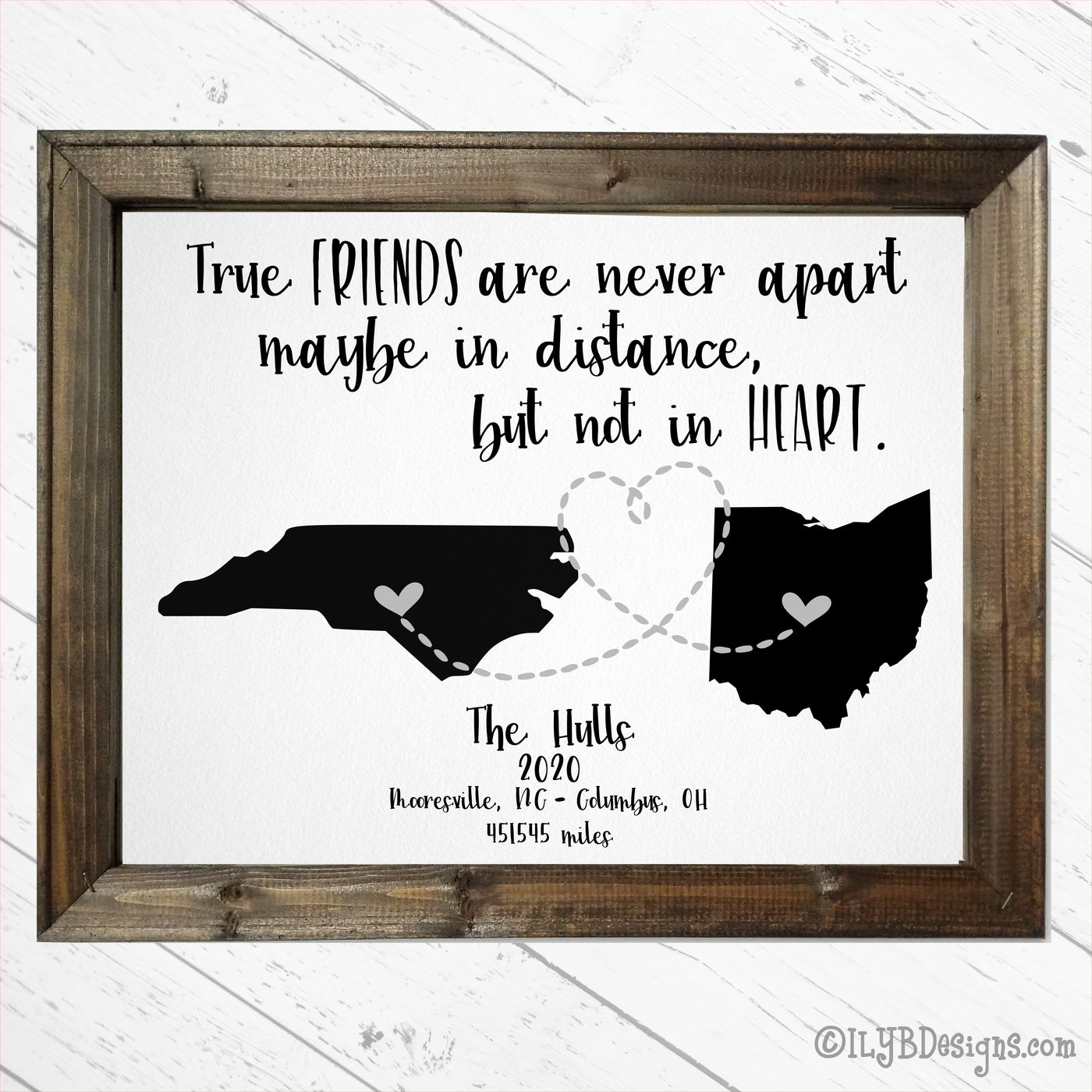 Dark walnut stained frame on a white canvas. Black script writing says, "True friends are never apart, maybe in distance, but not in heart." Below the script are 2 state silhouettes with small hearts and a dotted line heart connecting the 2 states. Under the states is a family name in script, along with the year, then the city and state for both states and the miles that connect the 2 locations. The frame measures 16"x20".