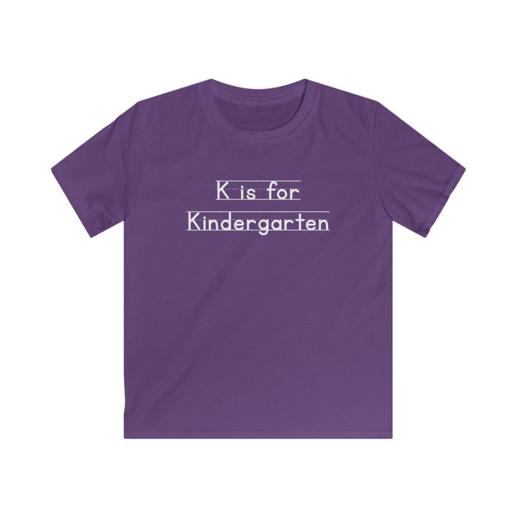 Purple shirt with white lettering that says K is for Kindergarten in a charming font that mimics primary writing paper lines.